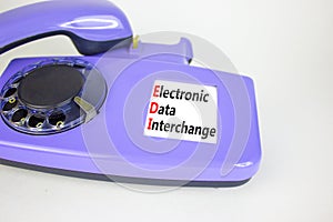 EDI electronic data interchange symbol. Concept words EDI electronic data interchange on old disk phone. Beautiful white