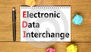 EDI electronic data interchange symbol. Concept words EDI electronic data interchange on white note. Beautiful wooden table