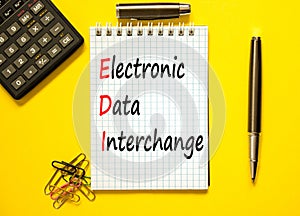 EDI electronic data interchange symbol. Concept words EDI electronic data interchange on white note. Beautiful yellow background.