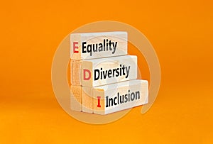 EDI equality diversity inclusion symbol. Concept words EDI equality diversity inclusion on blocks. Beautiful orange background.