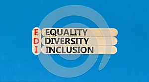 EDI equality diversity inclusion symbol. Concept words EDI equality diversity inclusion on wooden stick. Beautiful blue background