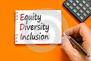 EDI equity diversity inclusion symbol. Concept words EDI equity diversity inclusion on white note. Beautiful orange background.