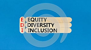 EDI equity diversity inclusion symbol. Concept words EDI equity diversity inclusion on wooden stick. Beautiful blue background.