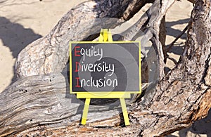 EDI equity diversity inclusion symbol. Concept words EDI equity diversity inclusion on yellow blackboard. Beautiful old tree