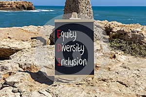 EDI equity diversity inclusion symbol. Concept words EDI equity diversity inclusion on yellow blackboard. Beautiful stone sea