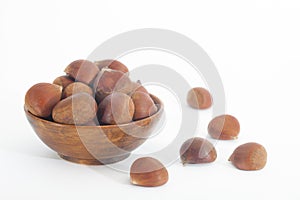 Edible chestnuts in wooden bowl on white background photo