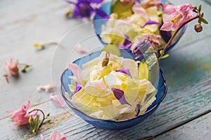 Edible flowers salad in a plate on blue wooden table with fork