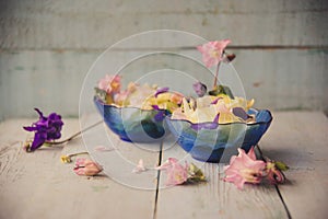 Edible flowers salad in a plate on blue wooden table with fork