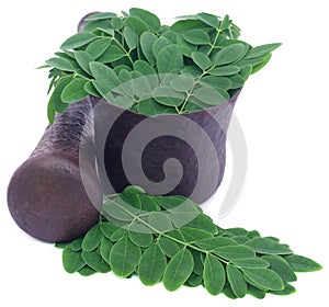 Edible moringa leaves in a vintage mortar