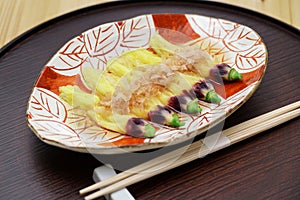 edible okra flowers soaking in dashi stock and sprinkled with bonito flakes