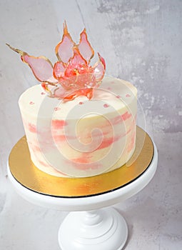 An edible red isomalt flower on top of a cake photo