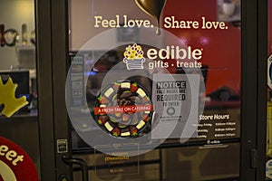 Edibles Gift and Treats retail store at night covid-19 sign in window