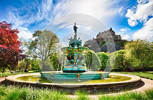 Edinburgh Castle in blue sky, sun and clouds and Ross Fountain, Scotland - UK