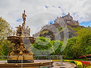 Edinburgh Castle and Ross Fountain seen from the Princes Street Gardens on a bright sunny day.