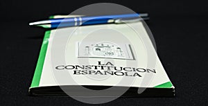 Book of the spanish constitution wiht a pen and the graphical white background
