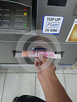 Editorial photo, indonesia, east jakarta, 10th october 2022, close up man hand make at financial transaction at ATM BCA