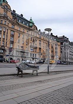 Man sleeping on a bench at the sidewalk