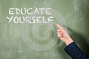 Educate Yourself. Woman points finger at text. Green chalk board