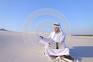 Educated male Muslim architect sits with gadget and drawing in h