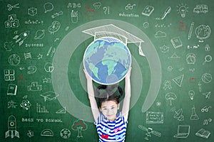 Educated school child girl lifting world globe doodle on chalkboard for children`s education international children day photo