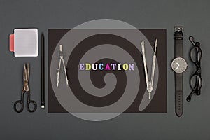 Education of architecture - black paper, text `Education` of wooden letters, engineering tools, eyeglasses, scissors, sketchbook