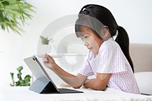 Education. Asian little girl learning and drawing with the online teacher on tablet digital, Application on mobile at home morning