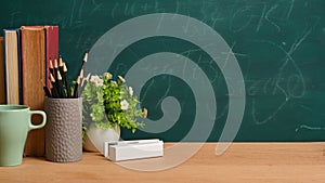 Education or back to school concept. books, pencils over green blackboard background