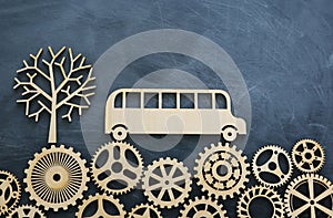 Education and back to school concept. Top view photo of school bus over wooden gears as concept of success and achievement and