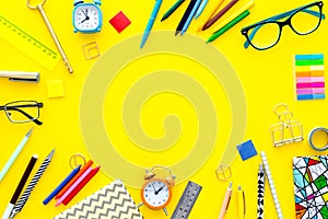 Education background, frame. School, student, office supplies. Stationery, glasses, alarm clock, notebook on yellow