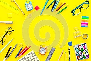 Education background, frame. School, student, office supplies. Stationery, glasses, alarm clock, notebook on yellow