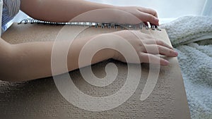 Education of blind, ill kid reading book written in Braille