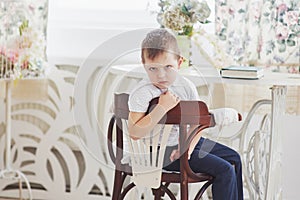 Education, childhood, people, homework and school concept - bored student boy reading book or textbook at home