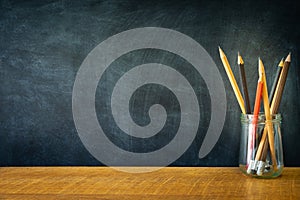 Education, Concept Back To School. School Supplies Border Banner front of chalkboard and Pencils in a glass bottle on wood table,