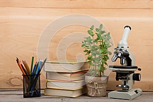 Education concept - books and microscope on the desk in the auditorium