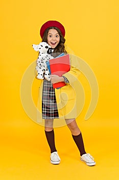 Education concept. childhood happiness. school and fashion. child in pupil uniform. kid in french beret on yellow