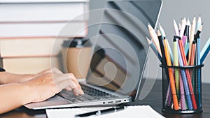 Education concept. Close up of female student make notes hand typing in laptop study online on computer from home. Woman typing in