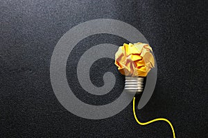 Education concept image. Creative idea and innovation. Crumpled paper as light bulb metaphor over black background
