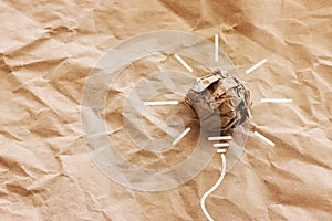 Education concept image. Creative idea and innovation. Crumpled paper as light bulb metaphor over brown background