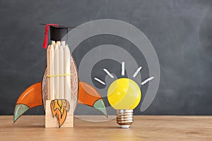 Education concept image. Creative idea and innovation. light bulb and rocket over blackboard background