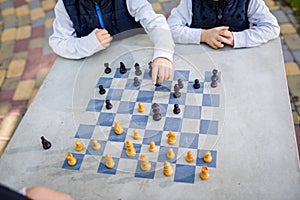 Education concept, intellectual game. Chess tournament, lesson, camp, training concept. Close-up hands of children playing chess