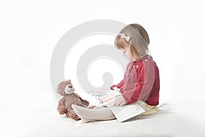 Education concept. playing school with toys. happy smiling baby girl elegant in dress. cute caucasian baby with teddy bear