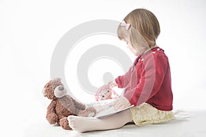 Education concept. playing school with toys. happy smiling baby girl elegant in dress. cute caucasian baby with teddy bear