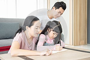 Education concept.Portrait enjoy happy smiling love asian family father and mother with little asian girl learning and writing in