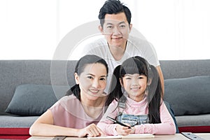 Education concept.Portrait enjoy happy smiling love asian family father and mother with little asian girl learning and writing in