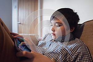 Education concept,School Kid holding tablet reading E-book for homework,Portrait happy Child playing game online on internet with