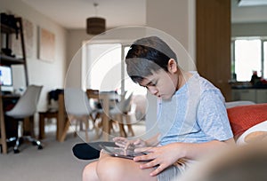 Education concept,School kid using tablet reading story from internet,Boy studying online learning at home,Child holding digital