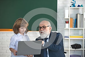 Education concept. School lesson. Help to learn. Old teacher with pupil. Old teacher with schoolboy in classroom.