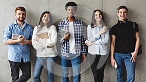 Education concept. Students smiling to camera over grey wall