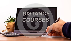 Education concept. Tablet with text `distance courses`. Online education during COVID-19 quarantine. Male hand with pen, photo
