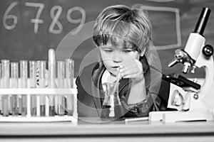 Education concept. Wunderkind experimenting with chemistry. Boy test tubes liquids chemistry. Chemical analysis